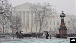 La nieve cae sobre el edificio de la Corte Suprema de Justicia en Washington.