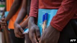 FILE - Newly released child soldiers receive school supplies as part of a reintegration kit which includes clothing and mosquito nets during a release ceremony for child soldiers in Yambio, South Sudan, on Feb. 7, 2018.