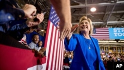 Democratic presidential candidate Hillary Clinton greets a member of the audience as she arrives to speak at a rally at Johnson C. Smith University in Charlotte, N.C., Sept. 8, 2016.