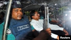 FILE - Mohammad Kamaruzzaman, center, assistant secretary general of the Jamaat-e-Islami party, sits inside a police van. 