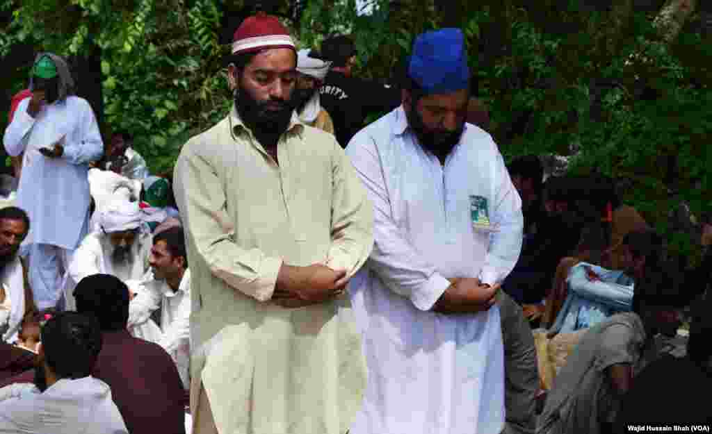 پاکستان عوامی تحریک کے کارکنان دھرنے کے دوران نماز ادا کر رہے ہیں۔