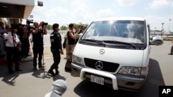 A van drives four refugees from Australia out of Phnom Penh International Airport, in Phnom Penh, Cambodia, Thursday, June 4, 2015. (AP Photo/Heng Sinith)