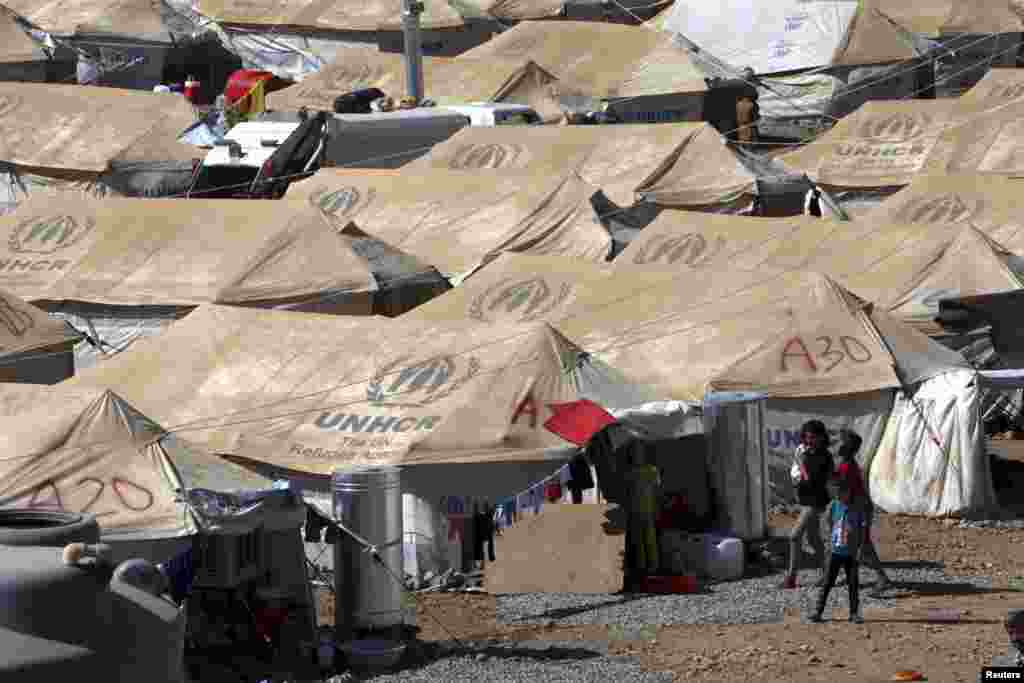 Syrian refugees walk at a new refugee camp in the outskirts of the city of Arbil in Iraq&#39;s Kurdistan region, August 26, 2013.