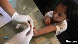 Una niña de Myanmar es sometida a un análisis de sangre para comprobar que no tiene malaria.