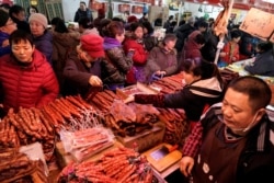 Descripción: Los clientes seleccionan "la rou", un manjar de cerdo curado y salchichas en un mercado antes del Año Nuevo Lunar chino en Beijing, China, 16 de enero de 2020. Fotografía tomada el 16 de enero de 2020. Reuters.