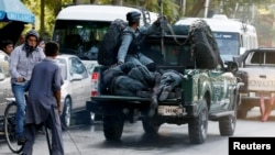 FILE - Injured policemen are transported at the back of a police vehicle after a suicide attack in Kabul, Afghanistan, Sept. 5, 2016. 