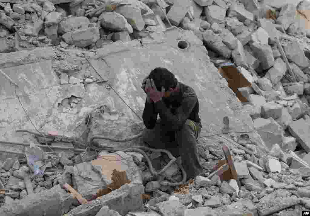 A Syrian boy mourns in the rubble of a building following a reported air strike by government forces on the rebel held area in the east of the northern Syrian city of Aleppo.