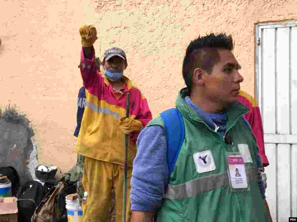 Rescue worker (rear, dressed in yellow) holds up his arm to request silence as they search for earthquake survivors in Mexico City, Mexico, Sept 21, 2017. (Photo: C. Mendoza / VOA) 