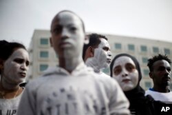 In this Wednesday, Feb. 7, 2018 photo, African migrants chant slogans during a protest in front of the Rwanda embassy in Herzeliya, Israel.