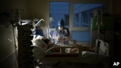 A nurse watches over a COVID-19 patient on a ventilator in the COVID-19 intensive care unit at the la Timone hospital in Marseille, southern France, Dec. 31, 2021.