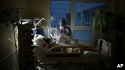 Medicinska sestra brine o pacijentu obolelom od kovida 19 prikačenom na respirator u intenzivnoj nezi u bolnici u Marseju, 31. decembra 2021. (Foto: AP/Daniel Cole