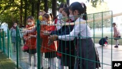 School children wash their hands to help curb the spread of the coronavirus before entering Kim Song Ju Primary School in Central District in Pyongyang, North Korea, Oct. 13, 2021.
