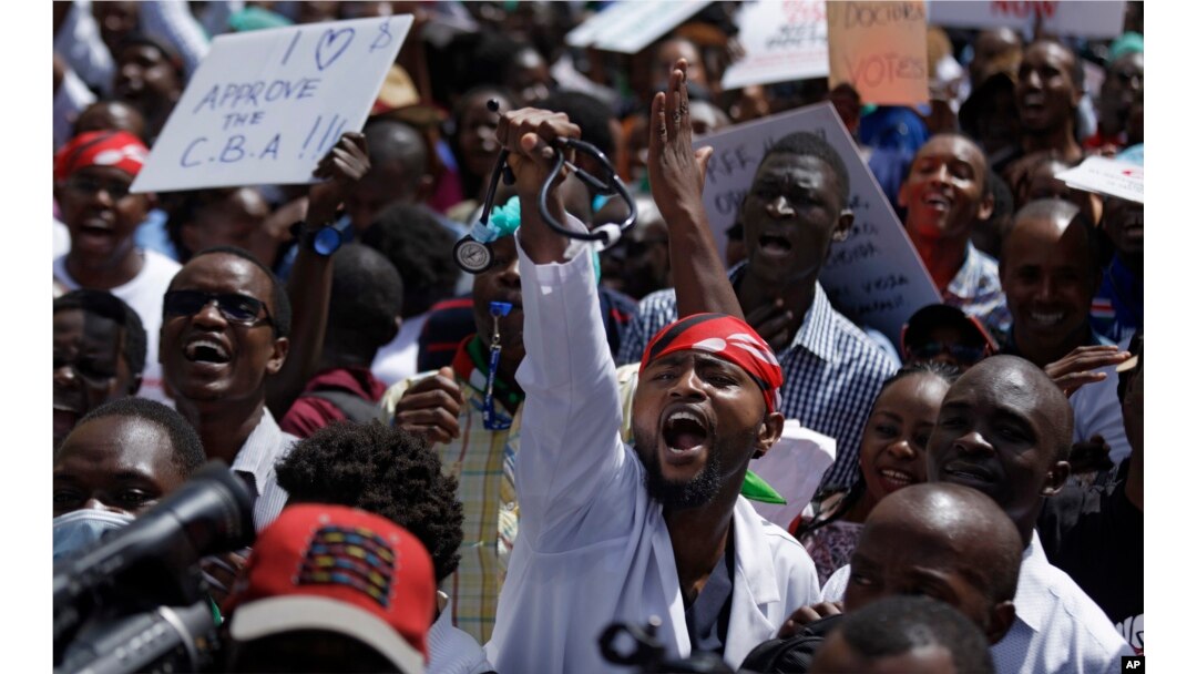 FILE - A doctor holds his stethoscope in the air as he and other medical staff protest the detention of their union leaders, outside an appeal court in Nairobi, Kenya, Feb. 15, 2017.