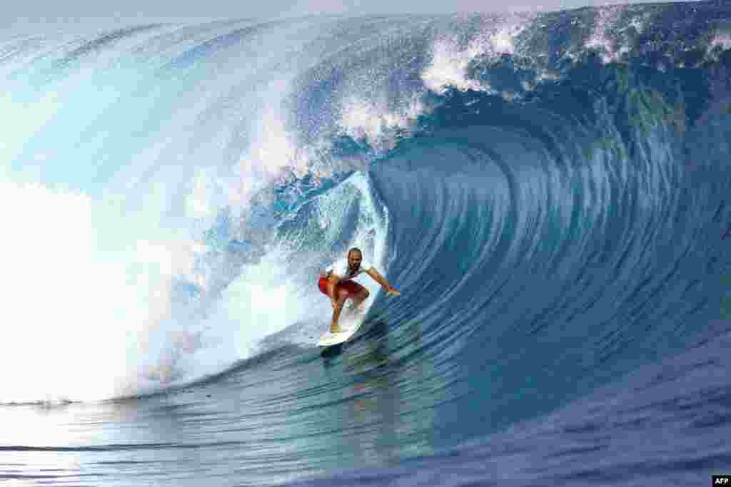 USA&#39;s C. J. Hobgood rides a wave during the 14th edition of the Billabong Pro Tahiti surf event, part of the ASP (Association of Surfing Professionals) world tour, in Teahupoo, on the French Polynesian island Tahiti, Aug. 18, 2014.