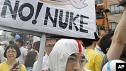 Anti-nuclear demonstrators wearing protective suits march down streets in Tokyo, Japan, June 11, 2011