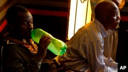 Un fidèle boit une bière faite maison lors d'un service de l'église Gabola dans un bar à Orange Farm, au sud de Johannesburg, le 15 avril 2018.