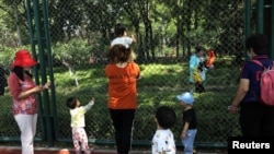 在北京一个公园里游玩的家长和儿童。（2021年6月1日）