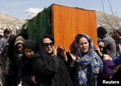 FILE - Afghan women's rights activists carry the coffin of Farkhunda, an Afghan woman who was beaten to death and set alight on fire March 19, during her funeral ceremony in Kabul, March 22, 2015.