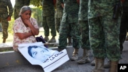 Mẹ của sinh viên Adan Abarajan de la Cruz, 23 tuổi bị mất tích ngồi trước cổng vào căn cứ quân sự ở Iguala de la Independencia, Mexico.