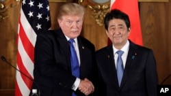President Donald Trump, left, shakes hands with Japanese Prime Minister Shinzo Abe during a joint news conference at the Akasaka Palace, Monday, Nov. 6, 2017, in Tokyo. 