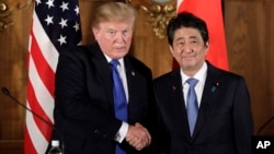 El presidente de EE.UU., Donald Trump, (izquierda) estrecha la mano del primer ministro de Japón, Shinzo Abe, durante una conferencia de prensa conjunta en el palacio Akasaka, en Tokio, el lunes, 6 de noviembre de 2017.