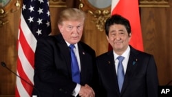 FILE - President Donald Trump, left, shakes hands with Japanese Prime Minister Shinzo Abe during a joint news conference at the Akasaka Palace, Monday, Nov. 6, 2017, in Tokyo.