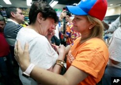 Rita Sanchez, (derecha) y Miriam Abraham junto a otros venezolanos residentes en Doral, Florida, reaccionan a las noticias provientes de Venezuela el martes, 30 de abril de 2019.