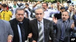 Syrian protesters throw eggs toward Abdul-Aziz al-Khair, a member of the Syrian National Coordination Committee, center, and other opposition leaders as they try to enter the Arab League headquarters in Cairo