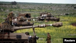 Israeli soldier stands by mobile artillery unit near town of Katzrin, Golan Heights, March 19, 2014.
