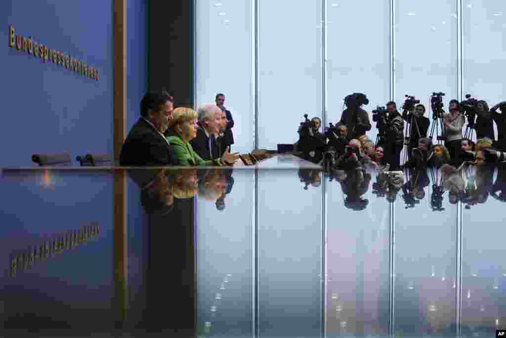 From left, German Social Democratic Party (SPD), chairman Sigmar Gabriel, Chancellor and chairwoman of the Christian Democratic Union (CDU), Angela Merkel and the chairman of the Christian Social Union (CSU), Horst Seehofer brief the media at a news conference after they signed a coalition agreement in Berlin.