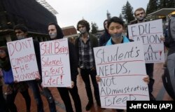 In this photo from 2014, students hold signs as they protest a series of tuition increases planned for the University of California