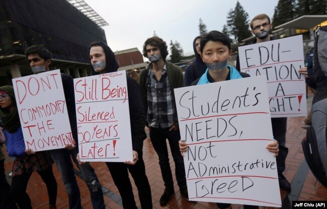In this photo from 2014, students hold signs as they protest a series of tuition increases planned for the University of California