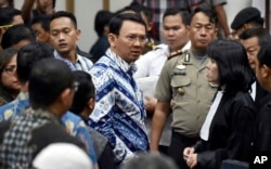 Jakarta Governor Basuki "Ahok" Purnama, center, talks to his lawyers after his sentencing in Jakarta, Indonesia.