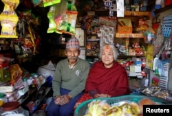 Nhuchhe Bahadur Amatya, 76, a retired accountant at Nepal Electricity Authority, along with his wife, Raywoti Devi Amatya, 74, a housewife, pose for a picture as they sit inside their shop in Lalitpur, Nepal, Feb. 4, 2018.