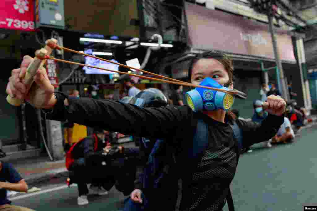 A demonstrator uses a slingshot during clashes with police at a protest against what they call the government&#39;s failure in handling the COVID-19 outbreak, in Bangkok, Thailand, Aug. 7, 2021.