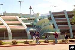 FILE - California State University, Northridge students walk past a parking structure at the Los Angeles campus that collapsed 25 years ago in the Jan. 17, 1994, earthquake.