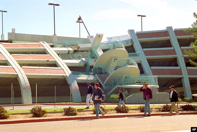 FILE - California State University, Northridge students walk past a parking structure at the Los Angeles campus that collapsed 25 years ago in the Jan. 17, 1994, earthquake.