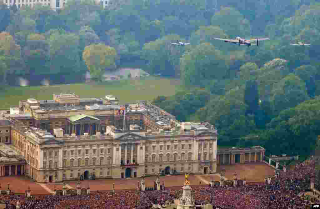 The Battle of Britain memorial Flight flies over Buckingham Palace as Britain's Prince William and his wife, Kate appear on the balcony, following their wedding. (AP Photo/Neil Chapman, Ministry of Defence)