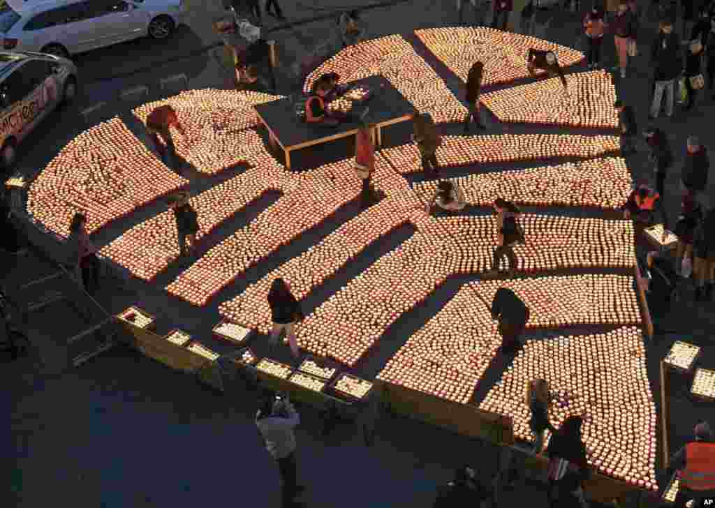 People construct a heart shape using over 12,000 tea candles during the Festival of Lights in Halle (Saale), eastern Germany, Nov. 3, 2013. 