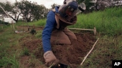 FILE - In this Dec. 3, 2001 file photo, former rebel soldier Abdul Momed Gofulof, clears land mines in Hnadane, 62 miles south of Maputo, Mozambique.