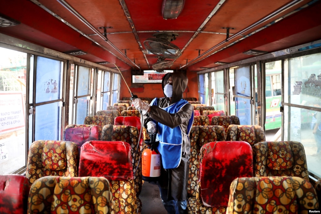 Un voluntario rocía desinfectante dentro de un autobús en medio de preocupaciones sobre la propagación de la enfermedad COVID-19, en Dhaka, Bangladesh.