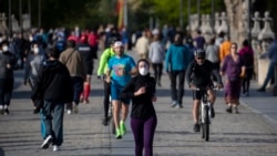 Personas cruzan el puente de Toledo en Madrid, España, el domingo 3 de mayo de 2020. El sábado, los españoles pudieron salir al aire libre para hacer ejercicio por primera vez en siete semanas desde que comenzó el encierro para combatir la COVID-19.