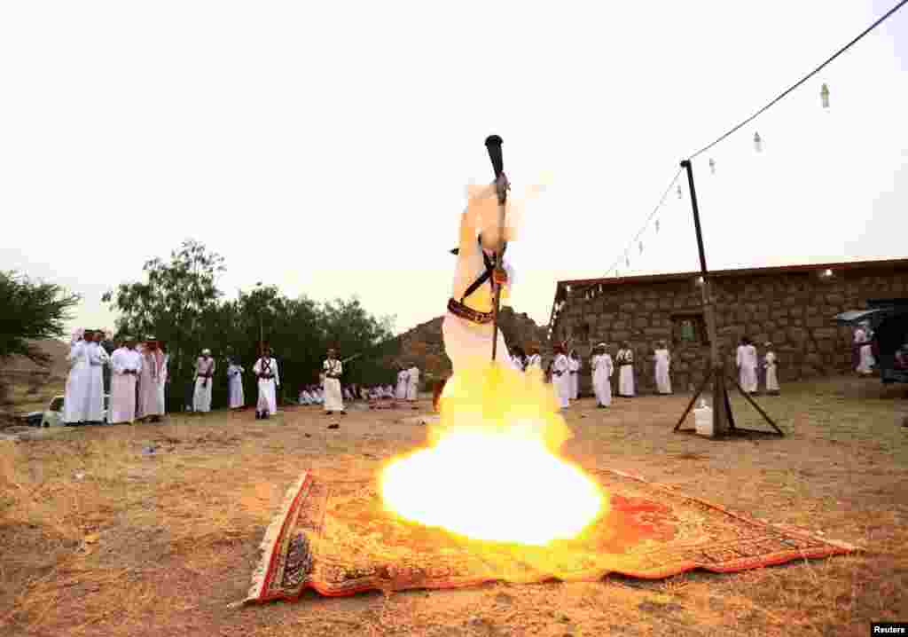 Seorang pria membakar sebuah senapan ketika menari dalam acara tradisional di dekat kota barat Saudi, Taif, 8 Agustus 2015.