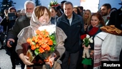 Nobel Prize in Literature laureate Svetlana Alexievich (L) is followed by her supporters after her arrival at Minsk's International Airport, Belarus, Dec. 15, 2015.