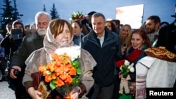 ជ័យ​លាភី​ពាន​រង្វាន់​ណូបែល​លោកស្រី​ Svetlana Alexievich (ឆ្វេង) តាម​ពី​ក្រោយ​ដោយ​អ្នក​គាំ​ទ្រ​ បន្ទាប់​ពី​អ្នក​ស្រី​មក​ដល់​ព្រលាន​យន្ត​ហោះ​អន្តរជាតិ​ក្រុង​ Minsk ប្រទេស​​បេឡារូស ថ្ងៃទី​១៥ ខែ​ធ្នូ ឆ្នាំ​២០១៥។