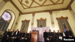 Members of Egypt's opposition coalition stand listen to the Egyptian national anthem before a news conference in Cairo, December 23, 2012. 