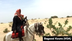 Un voyageur sur un cheval à la sortie du camp de Dar Es Salam à Baga-Sola (ouest du Tchad).