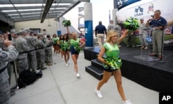 Seattle Seahawks NFL football Sea Gals cheerleaders greet troops at Joint Base Lewis-McChord, Washington, before a ceremony to transfer the team’s 12th Man Flag from U.S. Army soldiers who have returned from Afghanistan to U.S. Air Force air crews who fly cargo.