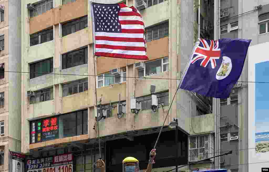 參與5-24港島反惡法遊行的示威者高舉美國旗及港英殖民時期的香港旗，在港版中國國家安全法實施後，可能觸犯相關法例。(美國之音湯惠芸拍攝)