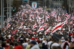 Protesters with old Belarusian national flags march during an opposition supporters rally in Minsk, Belarus, Sunday, Sept. 6, 2020.